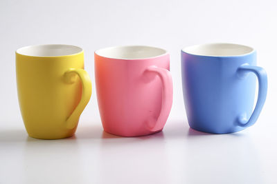 Colorful coffee cups against white background