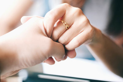 Cropped image of man holding girlfriend hand at table