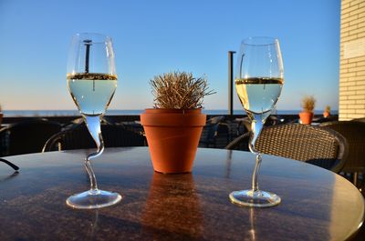 Glass of champagner on table against sky