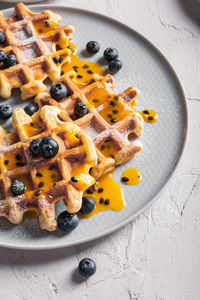 Breakfast with waffles with blueberries and syrup on a plates