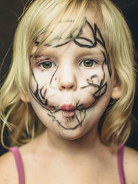 Close-up portrait of messy girl against black background