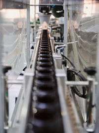 Row of plastic bottles on conveyor of filling machine at modern pharmaceutical manufacturing plant