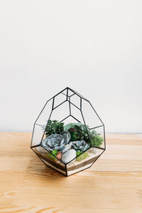 Close-up of wicker basket on table against wall