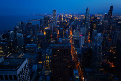 High angle view of illuminated buildings against sky at dusk