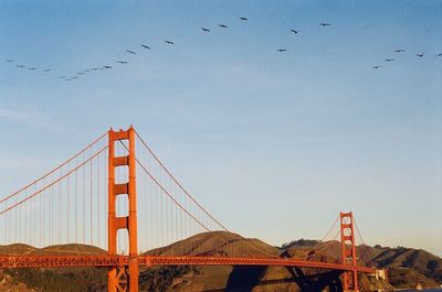 Low angle view of suspension bridge against sky