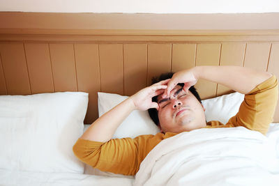 Midsection of man lying on bed at home