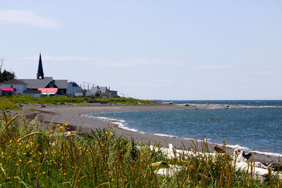 Scenic view of sea by buildings against sky