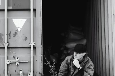 Thoughtful man looking away against warehouse