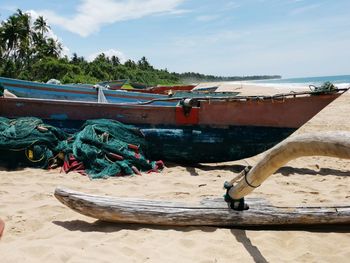 Fishing boat on beach against sky