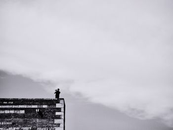 Low angle view of man standing against sky