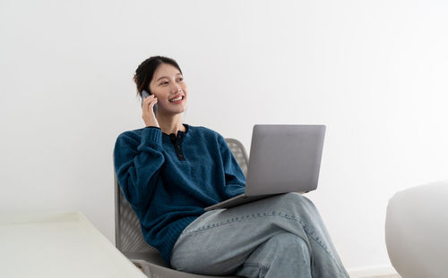 Businesswoman talking on call using laptop