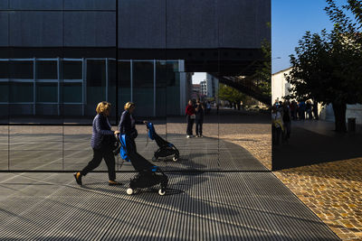 People walking on footpath in city