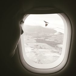 Cropped image of airplane flying over landscape