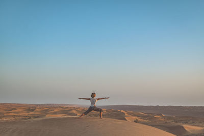 Woman practicing yoga in desert