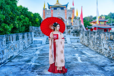 Asian woman wearing a red chinese culture dress visit santichon village, pai, mae hong son province,