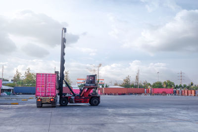 Vehicles on road against cloudy sky