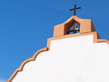 Low angle view of cross on church against clear blue sky