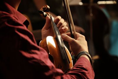 Midsection of man playing guitar