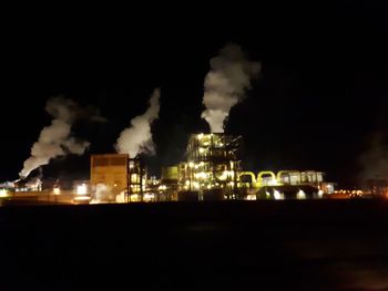 Smoke emitting from factory against sky at night