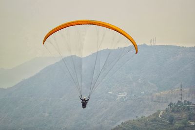 Person paragliding against sky