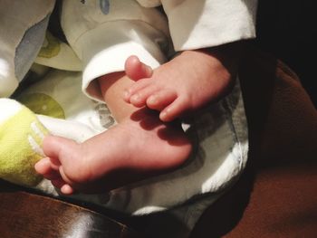 Close-up of hands holding baby at home