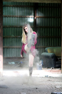 Full length of young woman throwing dust