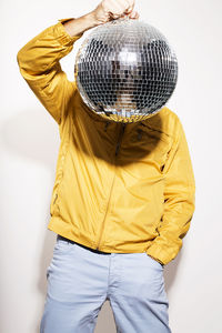 Man holding disco ball against white background