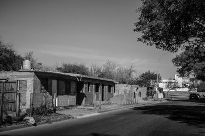 Road by buildings against sky