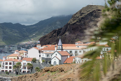 Town by mountain against sky