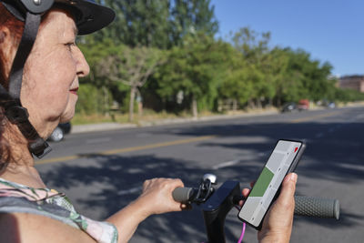 Smiling woman reading map on mobile phone screen