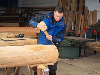 Portrait of man working on wood in workshop