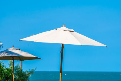 Umbrellas on beach against clear blue sky