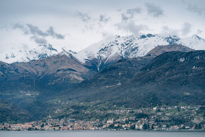 Scenic view of sea and snowcapped mountains against sky