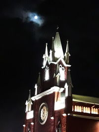 Low angle view of illuminated building against sky at night