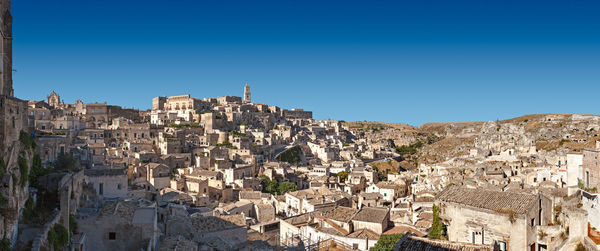 Aerial view of townscape against blue sky