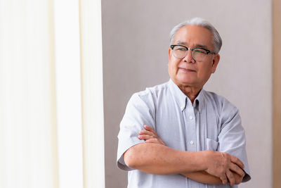 Portrait of young man sitting on bed at home