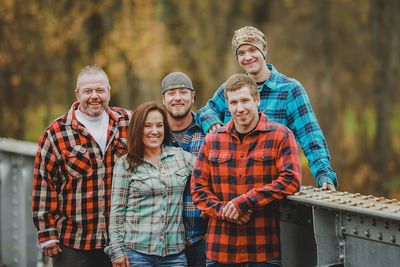 Portrait of smiling family standing by railing