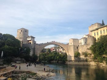 Arch bridge over river against sky