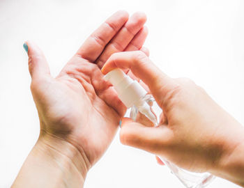 Female hands applying hand sanitizer gel