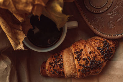 A cup of black morning coffee with a chocolate croissant. delicious meal. aesthetics in details. 