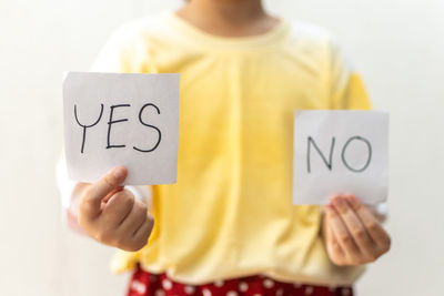 Midsection of woman holding paper with text