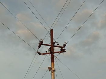 Low angle view of electricity pylon against sky