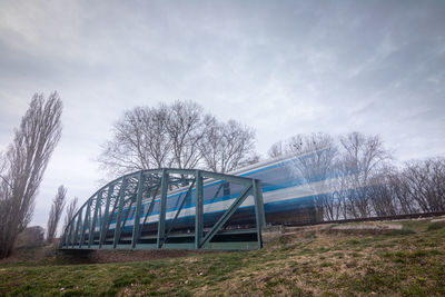 Metallic structure on field against sky