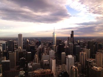 Modern cityscape against cloudy sky