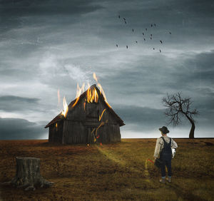 Surreal image of a farm burning as the man watches it burn. surrealism