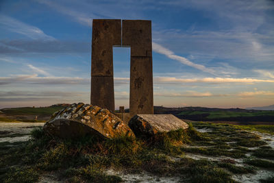 Old ruin on field against sky during sunset