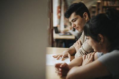 Male professor and student discussing in library