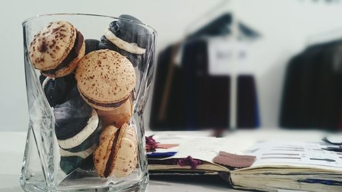 Close-up of cookies in glass jar with book on table