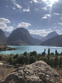 Scenic view of mountains and lake against cloudy sky