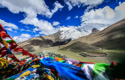 Colorful fabrics by mountains against sky